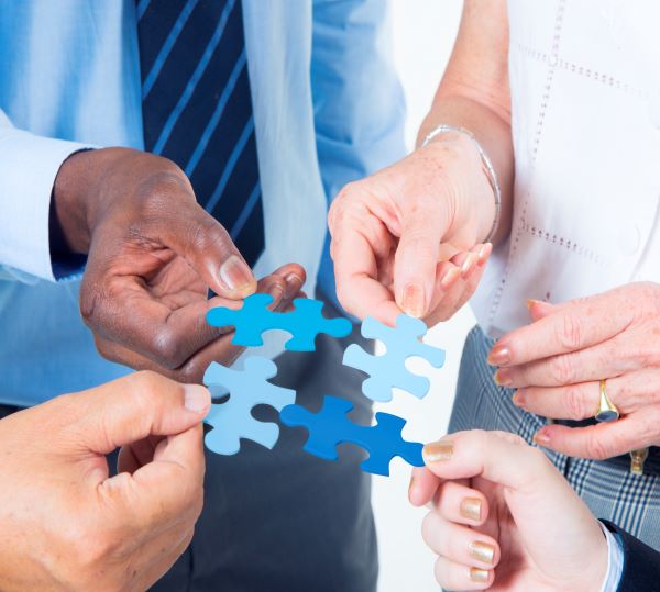 coworkers coming together to complete puzzle photo