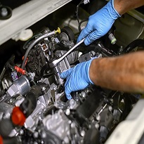 hands of mechanic working on car engine