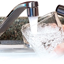 Water flowing out of a faucet into a glass