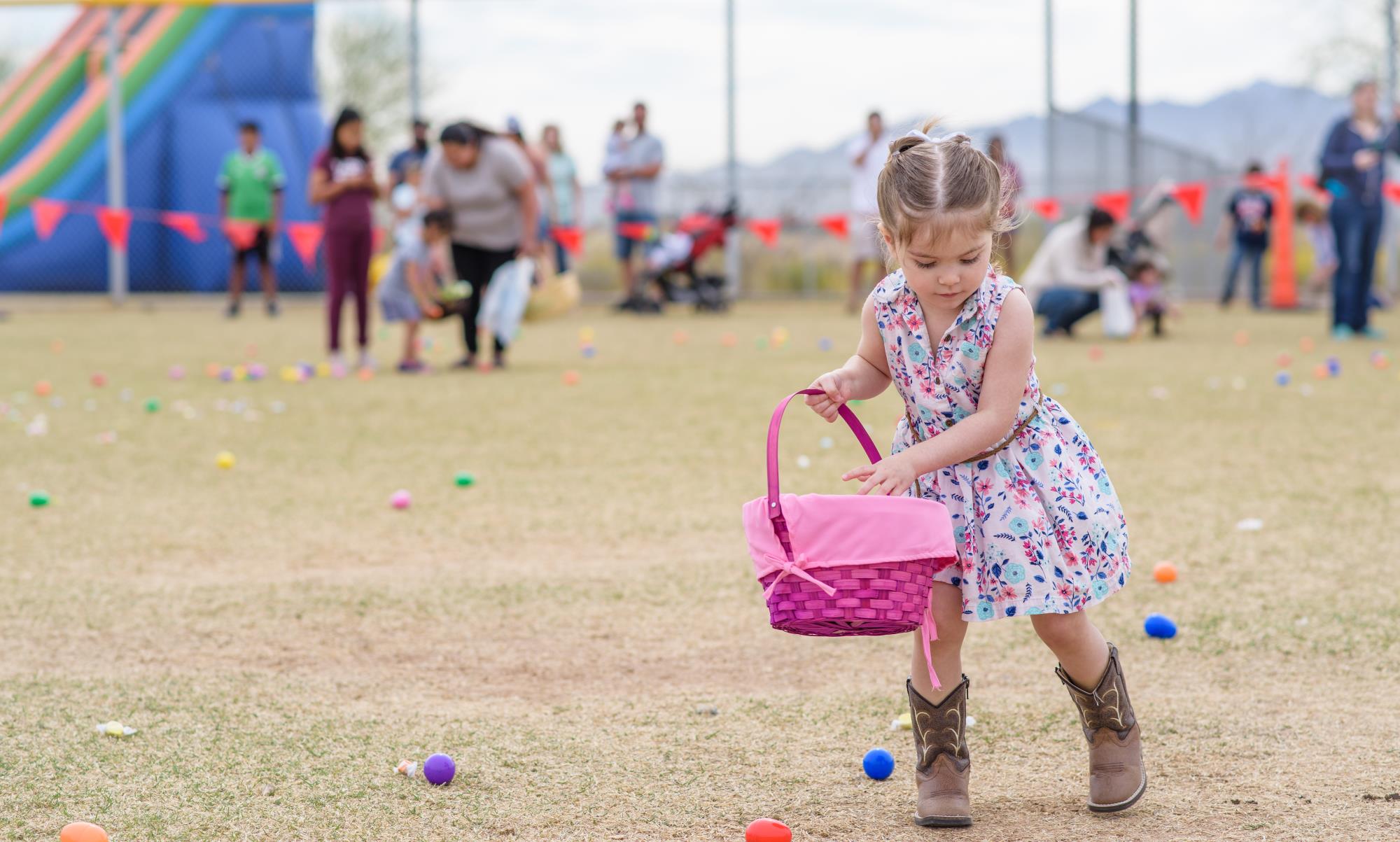 Little girl with basket hunting Easter eggs